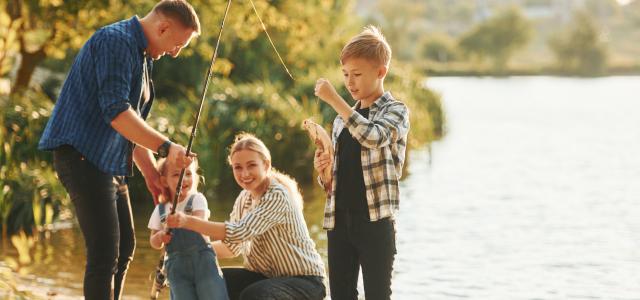 famille de quatre personnes pêchant au bord d'un lac